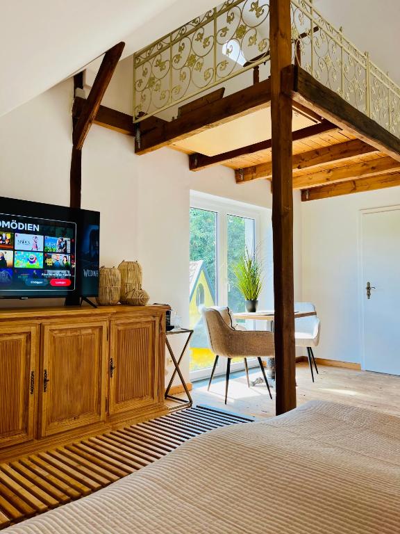 1 dormitorio con 1 cama, TV y mesa en b e d & a g e d e s i g n -large- wunderschönes Zimmer mit Bad - Rechnungserstellung für Geschäftsreisende & Firmen, en Hünxe