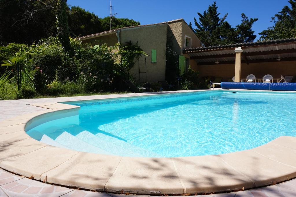 a swimming pool with blue water in a yard at Villa La Marpierre in Mondragon