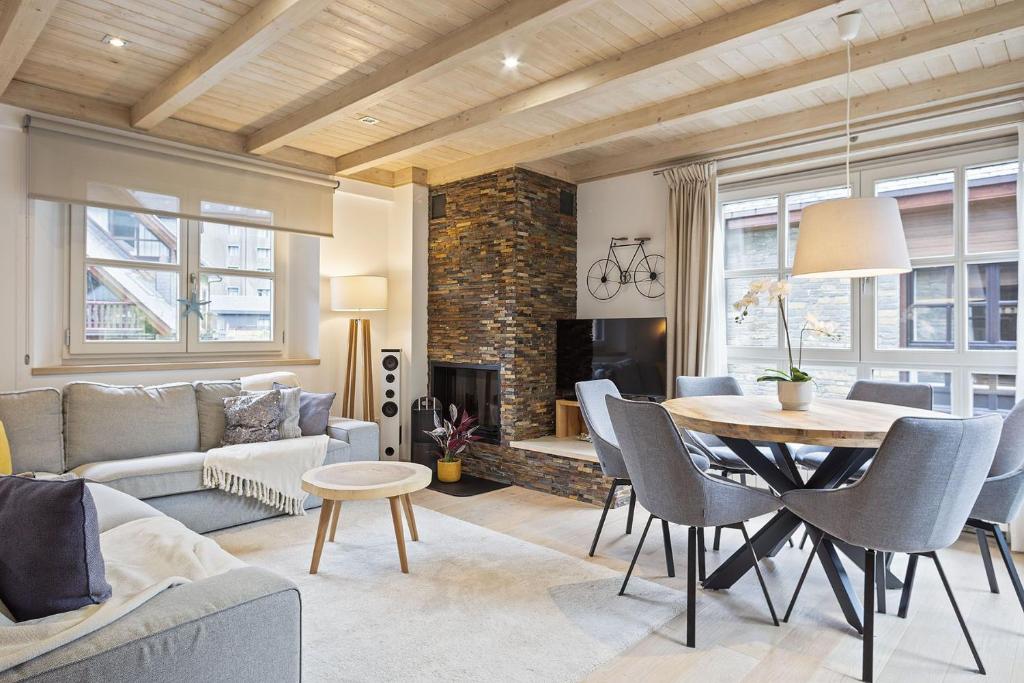 un salon avec un canapé, une table et des chaises dans l'établissement Luderna - Apartamento Val de Ruda A30 Manaud, à Baqueira-Beret