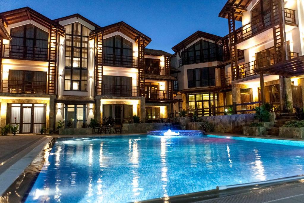 una casa grande con piscina frente a ella en Hotel ASSOL Meganom, en Sudak