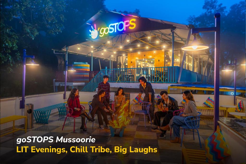 a group of people sitting in chairs outside at night at goSTOPS Mussoorie Clock Tower in Mussoorie