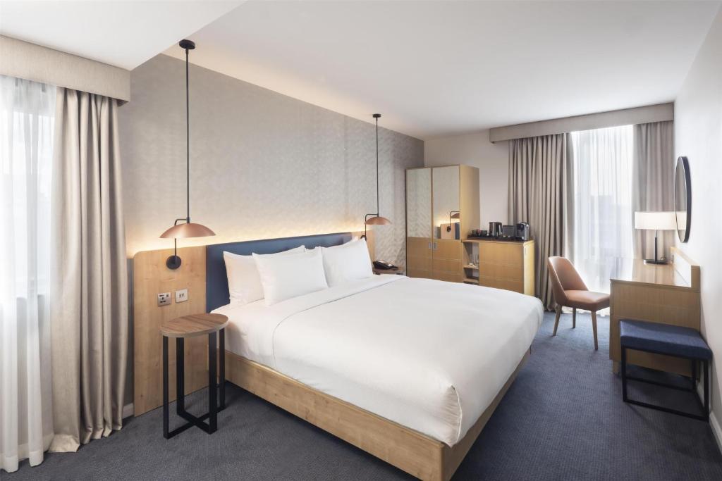 a hotel room with a large bed and a desk at Hilton Garden Inn Bristol City Centre in Bristol