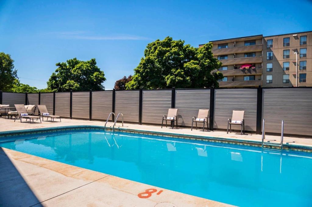 a swimming pool with chairs and a fence at Quality Inn in Chatham