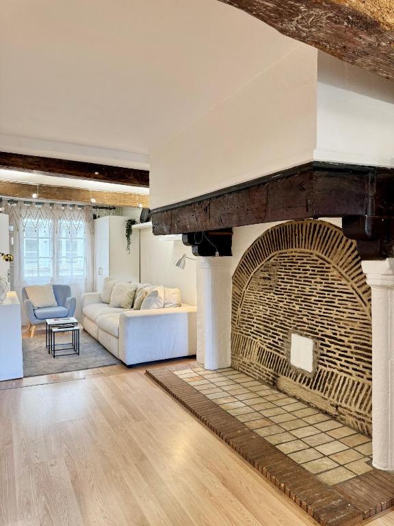 a living room with a large brick fireplace at Le Saint Georges avec terrasse, Hyper centre ville in Rennes