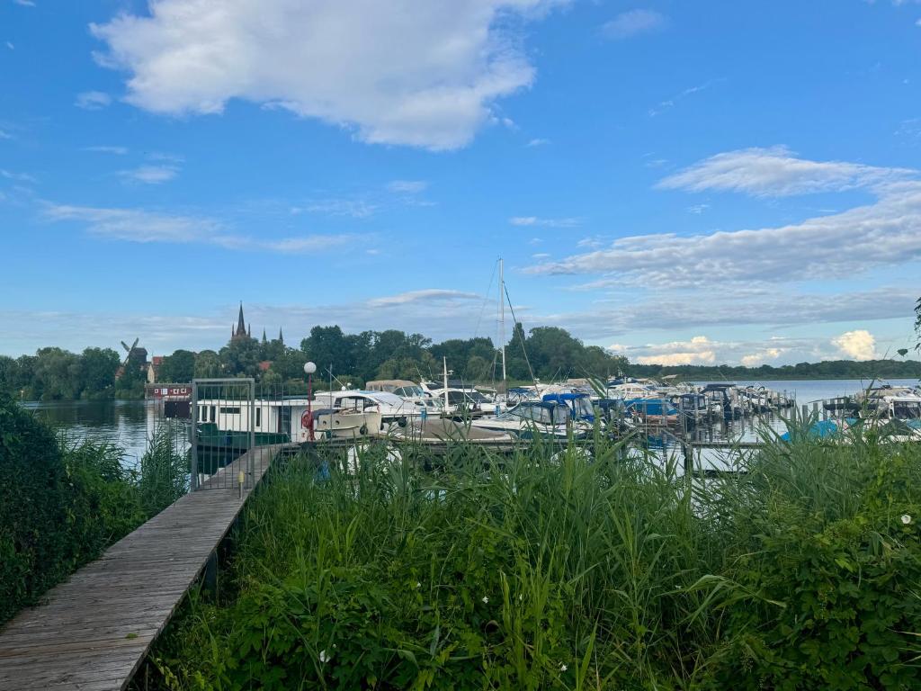 un muelle con barcos atracados en el agua en Ferienwohnung Weidenkörbchen am Wasser in Werder Havel, en Werder