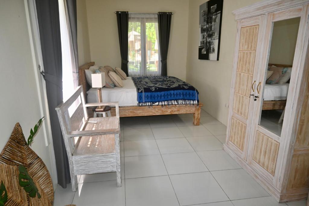een slaapkamer met een bed en een raam bij Villa Benih Cinta in Lovina