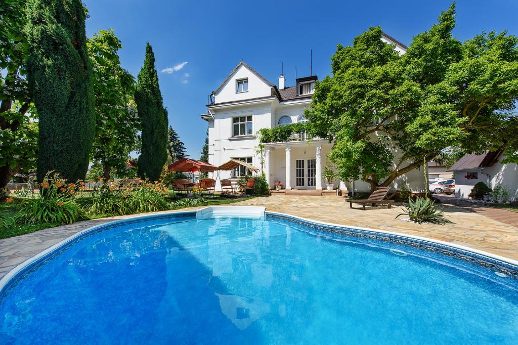 a large blue swimming pool in front of a house at Marie - Luisa in Prague