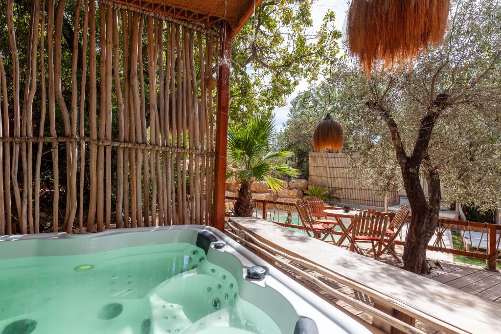 a jacuzzi tub on a deck with a patio at Bali House in Peypin