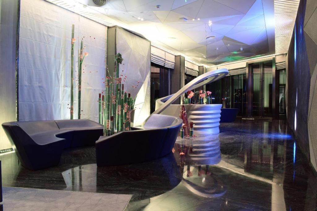 eine Lobby mit Stühlen und Pflanzen in einem Gebäude in der Unterkunft Cachet Boutique Shaoxing in Dongpu