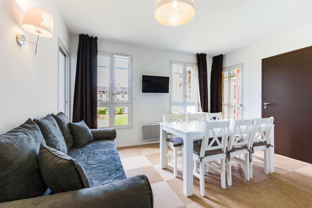 a living room with a couch and a table and chairs at Maya - Piscine - Calme - Parking in Baden