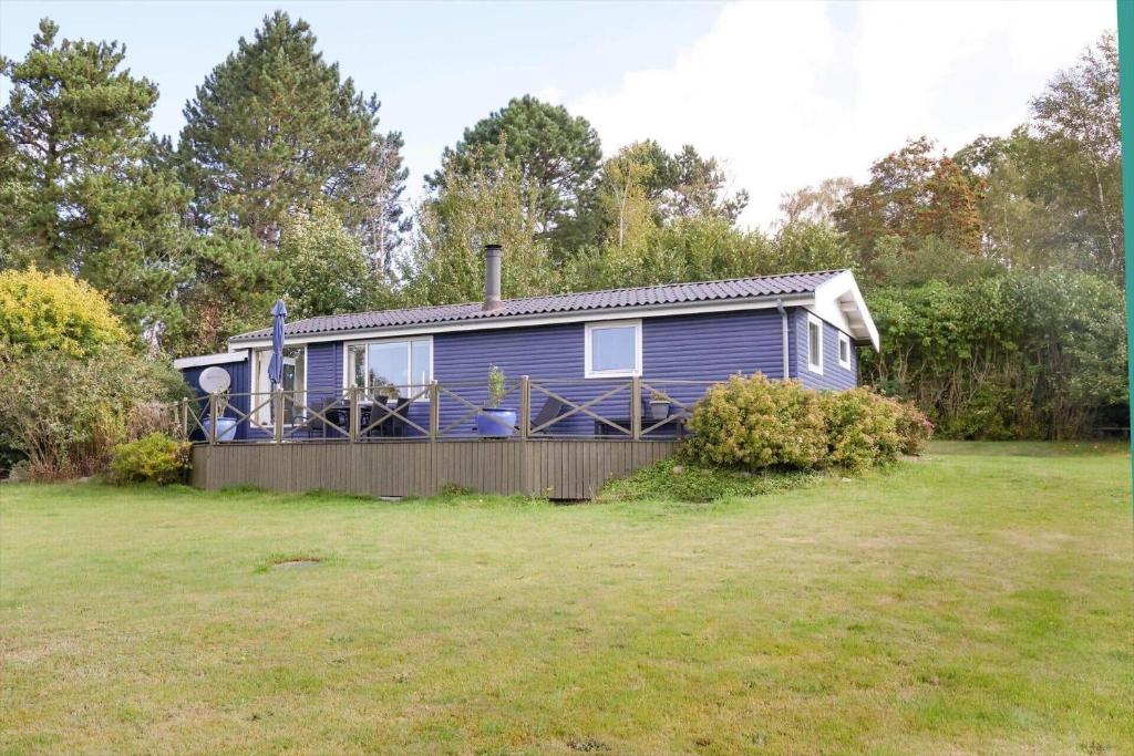a blue house with a fence in a yard at 16608-1-Farevejle-Horager-8 in Kårup