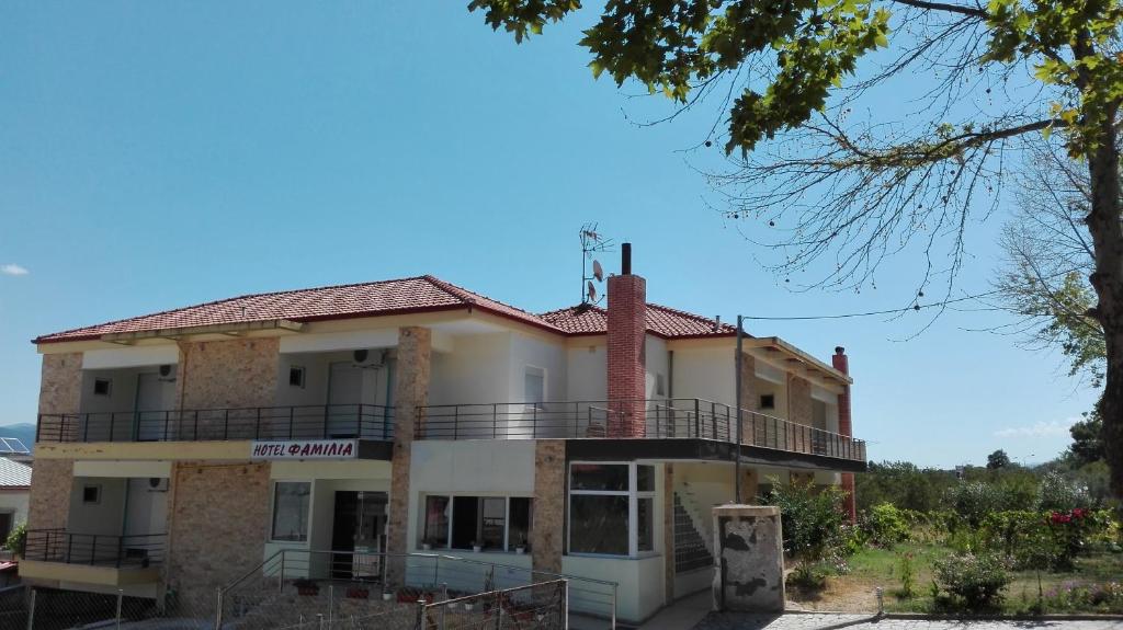 un edificio antiguo con balcón en la parte superior en Familia Hotel en Loutrá Vólvis