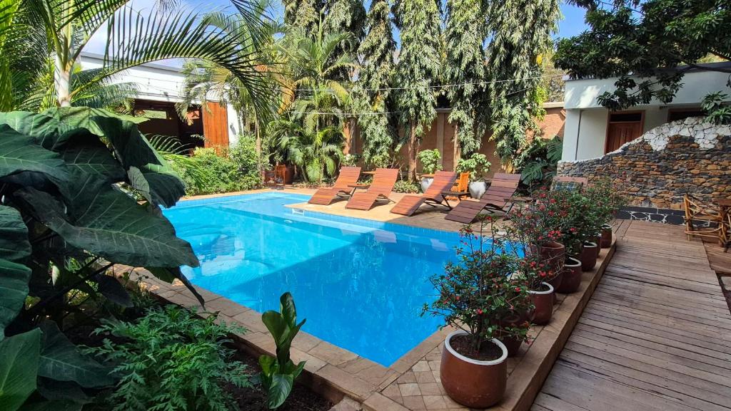 a pool with chairs and plants next to a house at Explorers Kilimanjaro Boutique Hotel in Moshi