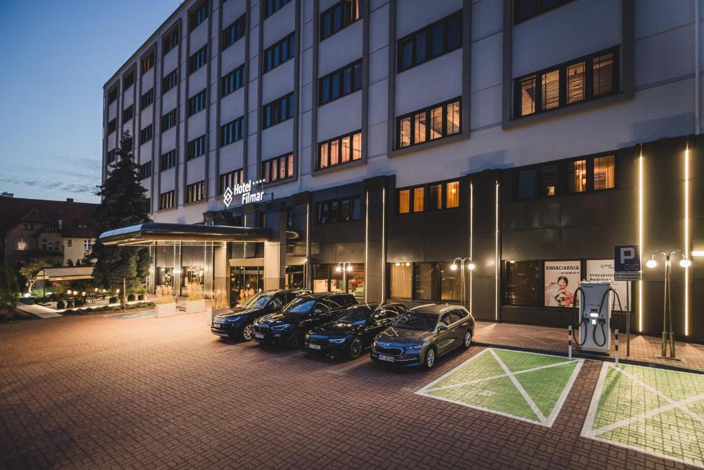 un grupo de coches aparcados delante de un edificio en Hotel Filmar, en Toruń