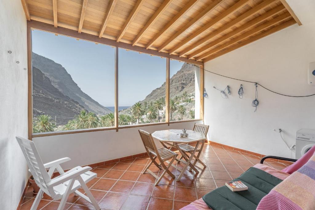 a living room with a table and chairs and a large window at Apartamento Nayara A in Calera