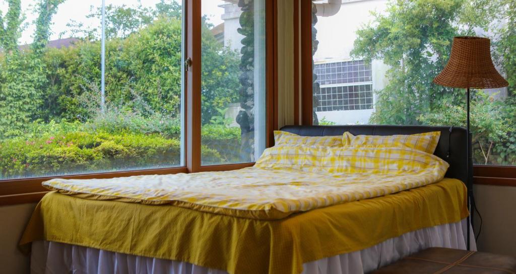 a bed in a room with a large window at Blue Sea Pension 