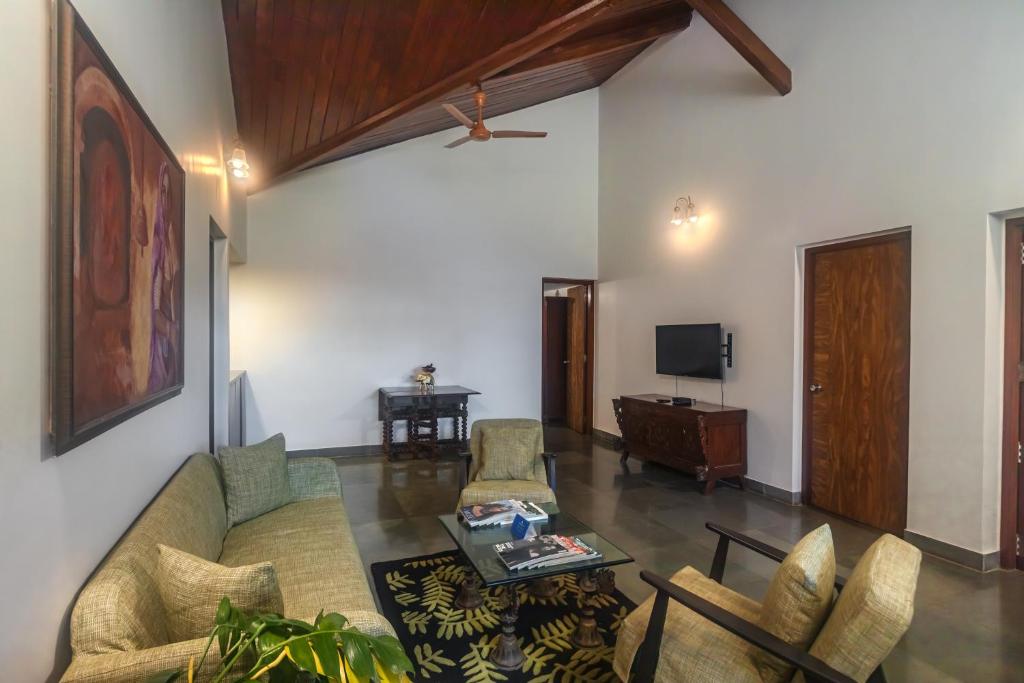 a living room with a couch and a table at SaffronStays Hidden Branches -3BR pet-friendly villa with infinity pool & forest views in Khandala in Lonavala