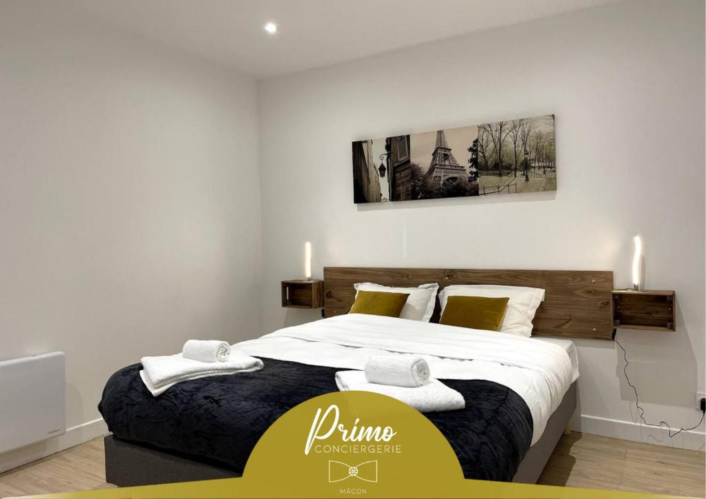 a bedroom with a large bed with towels on it at L'Aligoté - Appartement en coeur de ville By Primo in Sennecey-le-Grand