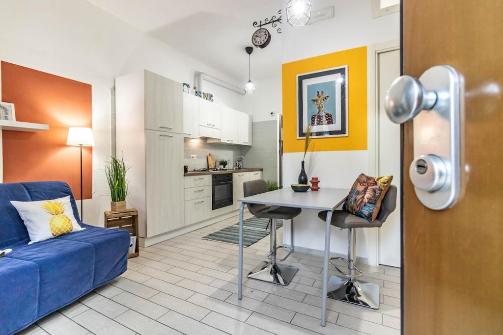 a living room with a blue couch and a kitchen at Residenza Il Torrione in Iesi