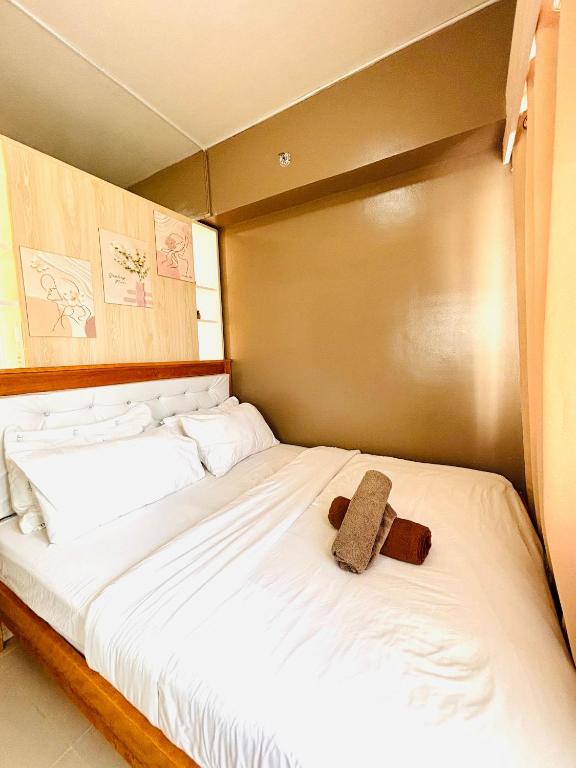 a teddy bear sitting on top of a bed at Convenient City Hub with Relaxing Interior in Mandurriao