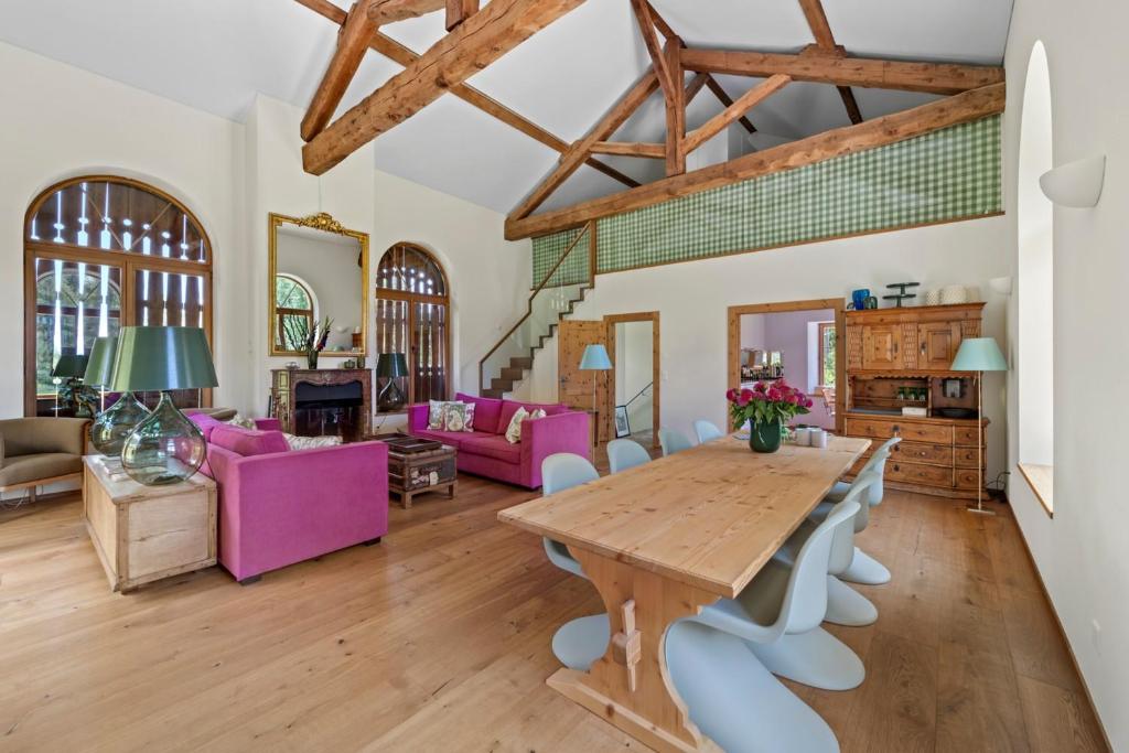 a living room with a wooden table and purple chairs at Abitaziun Acla Albanatscha - Silvaplana in Silvaplana