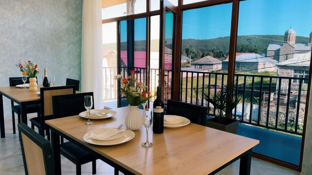 a dining room with tables and chairs and a large window at Hostel Tsalka in Tsalka