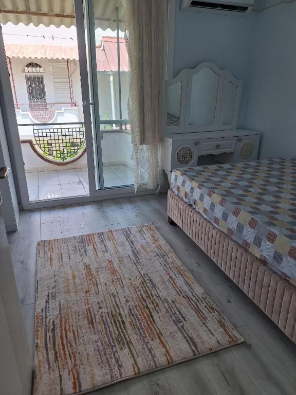 ein Schlafzimmer mit einem Bett und einer Glasschiebetür in der Unterkunft Çakır villa in Silifke