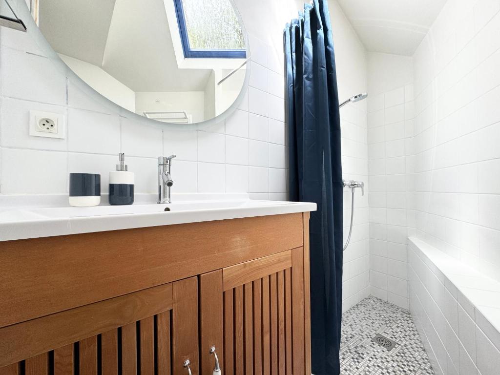 a bathroom with a sink and a mirror at Jolie maison rénovée au port de Sainte Marine in Combrit
