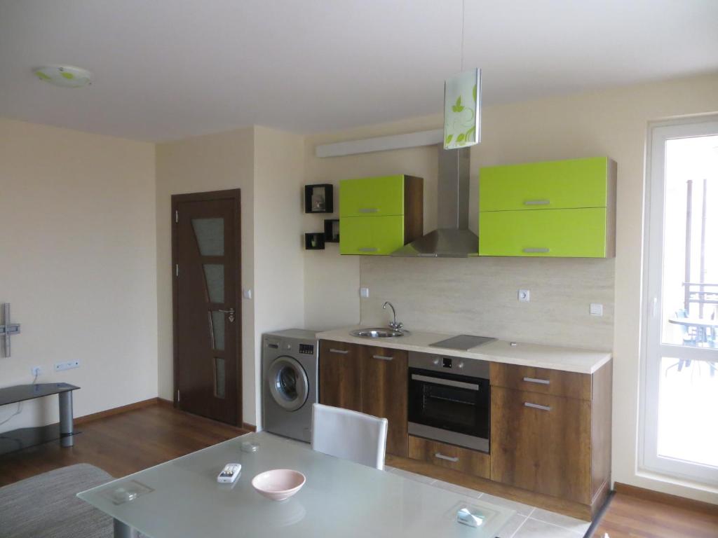 a kitchen with green cabinets and a stove top oven at Emona Apartment in Burgas City