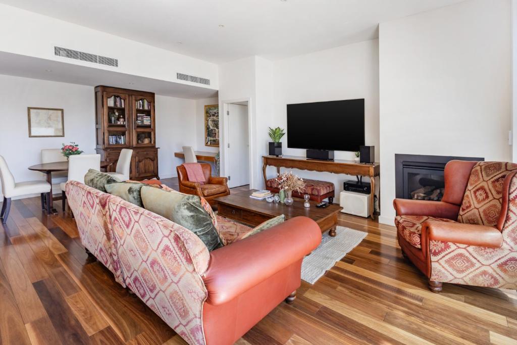 a living room with two couches and a television at Bright & Spacious Penthouse by Parliament House in Barton