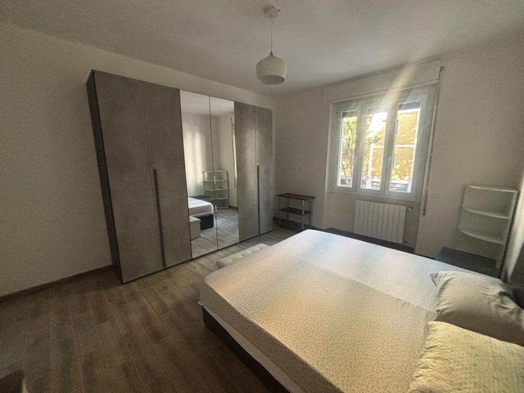 a bedroom with a bed and a large mirror at Appartamento Primavera in Cremona