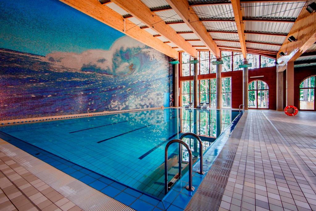 a swimming pool with a painting on the wall at Hotel Magellan in Bronisławów