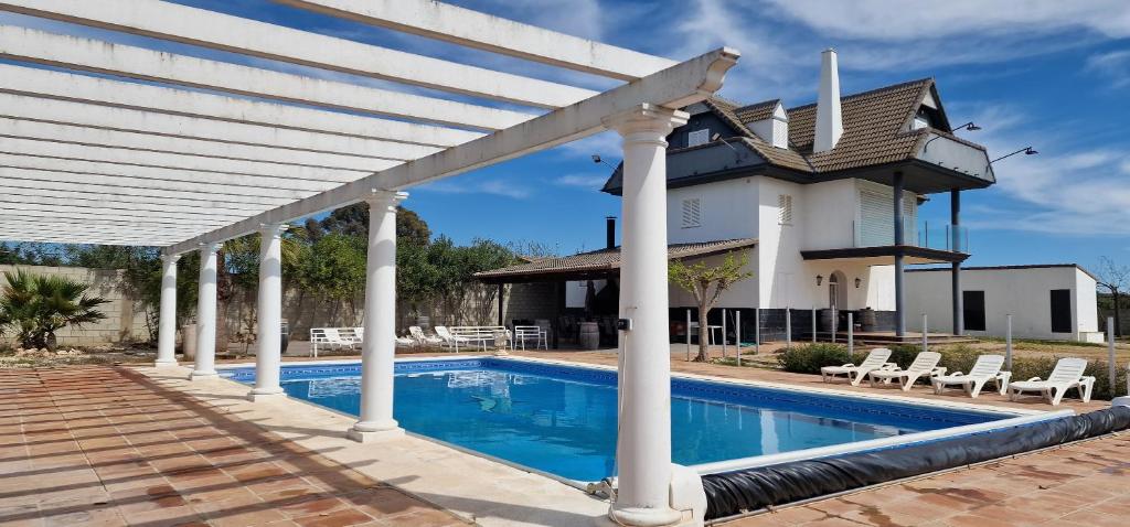 una casa con piscina delante de un edificio en Los Rosales De La Palmilla, en Montoro