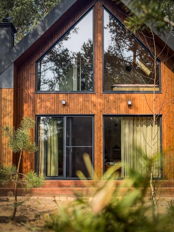 a wooden house with glass windows at Kwiat Sosny in Pszczew