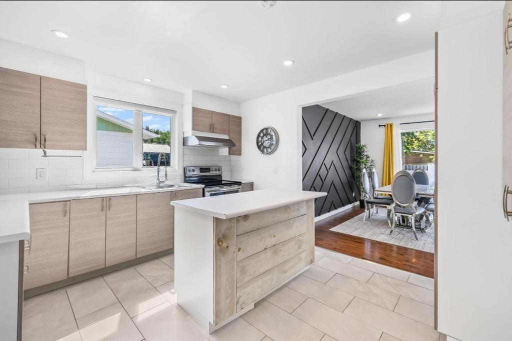 a kitchen with white countertops and a dining room at Luxury bungalow in Châteauguay in Châteauguay