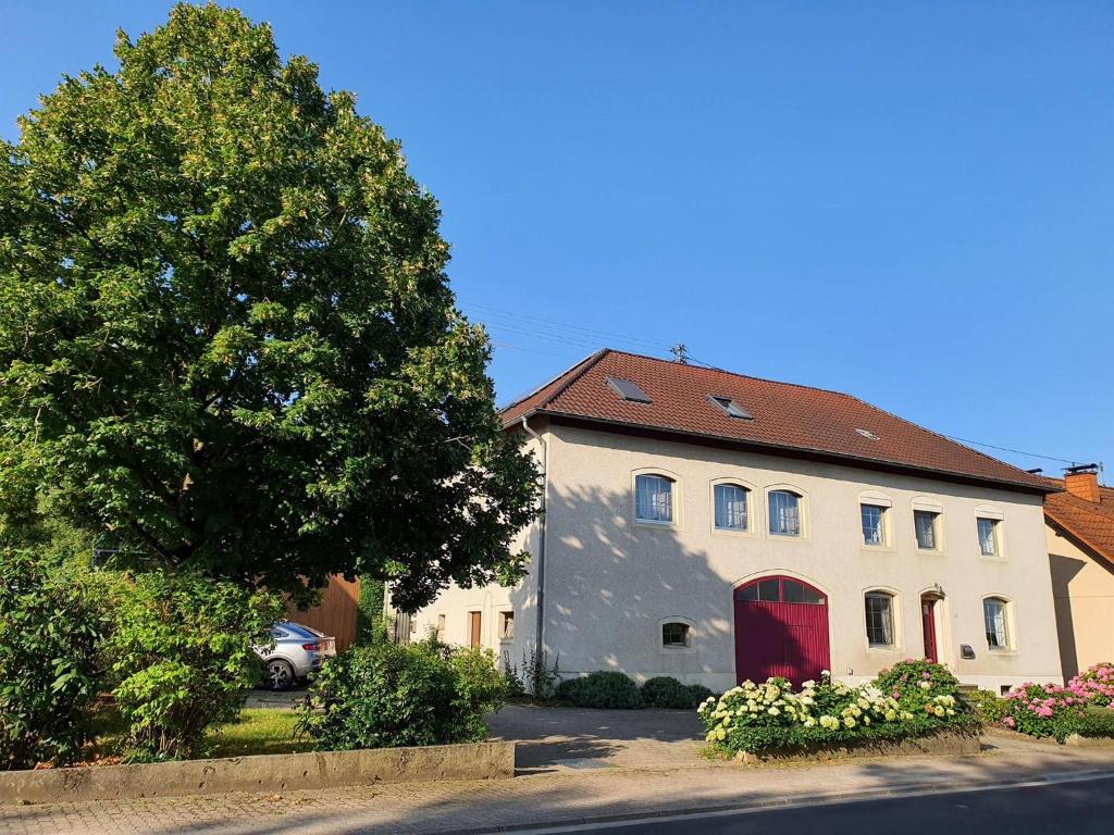 a large white house with a red door at Ferienwohnung Kirschenknupp in Hellendorf