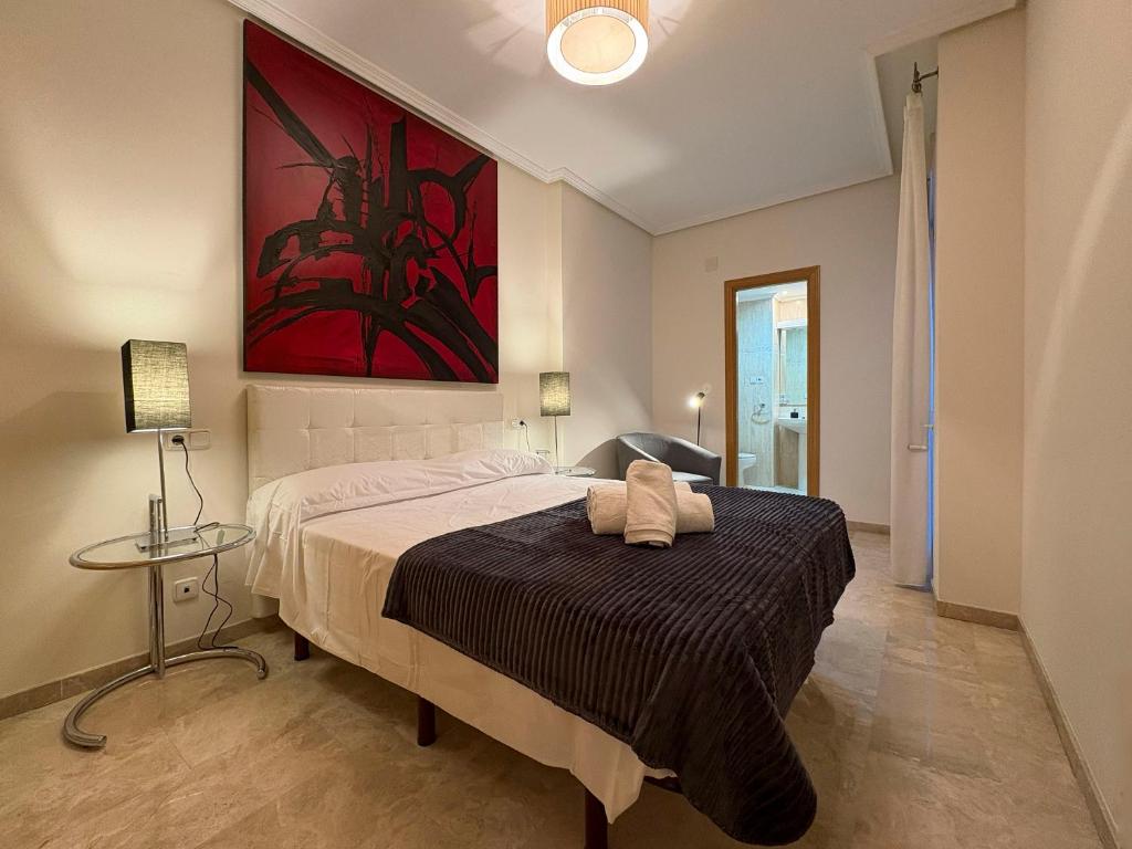 a bedroom with a bed and a painting on the wall at Los Amantes de Teruel viven aquí in Teruel