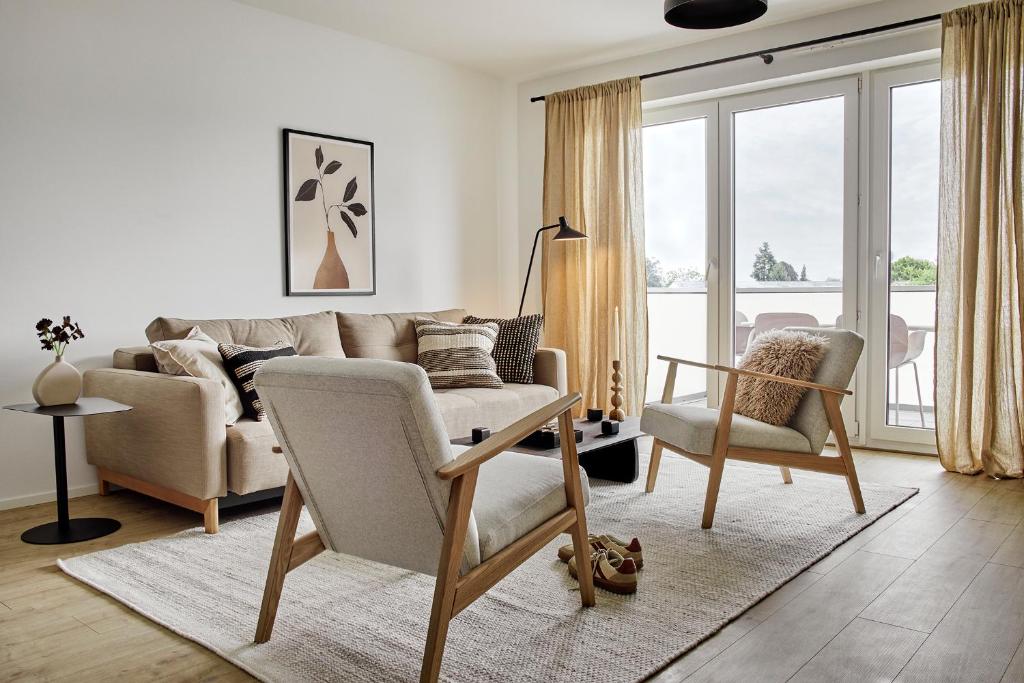 una sala de estar con un sofá y una silla en MATT - Apartments ' Design-Apartment mit Balkon, en Offenburg