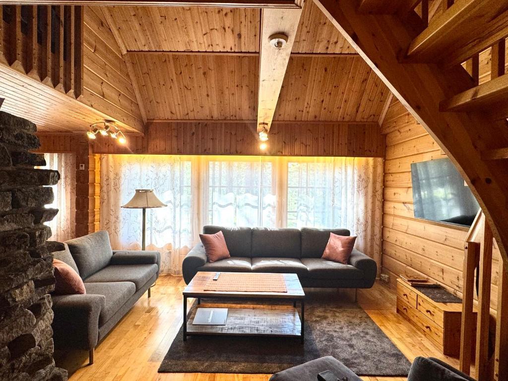 un soggiorno con un divano e un tavolo di Levi Isorakka Holiday Cabin Pistotie a Kittilä