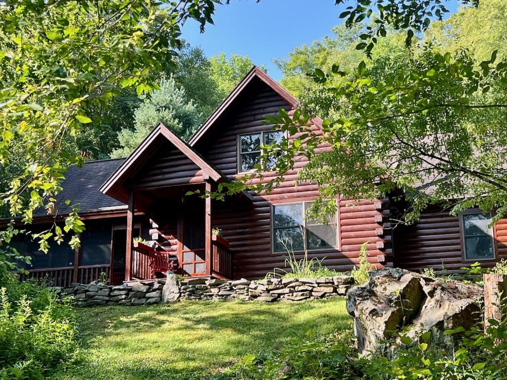 a log cabin in the woods with a yard at Perfect Vermont Battenkill Log Cabin in Arlington