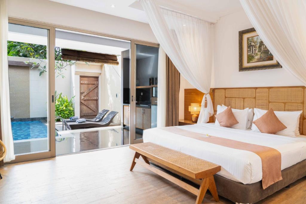 Un dormitorio con una cama tamaño king y un baño. en Lasanti Villas Seminyak, en Seminyak