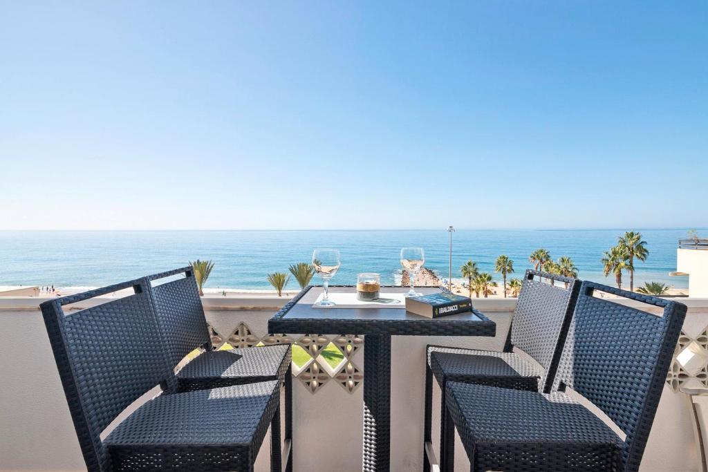 a table and chairs on a balcony with the ocean at Paraná in Quarteira