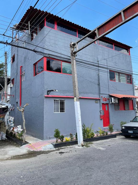 ein Gebäude mit einer roten Tür an einer Straße in der Unterkunft Home Nino in Guadalajara