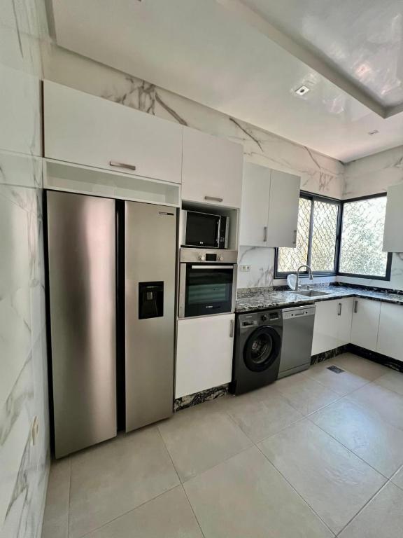 a kitchen with a stainless steel refrigerator and a dishwasher at Villa privée in Taazout