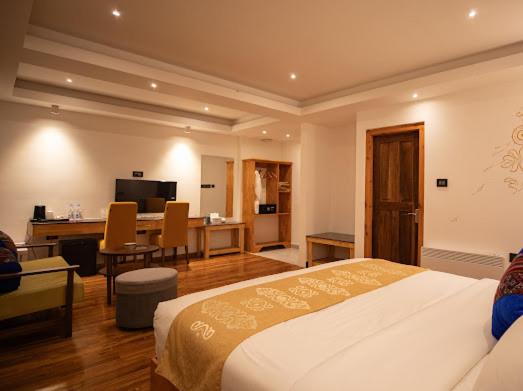 a bedroom with a bed and a desk and a kitchen at Nangter Retreat in Paro