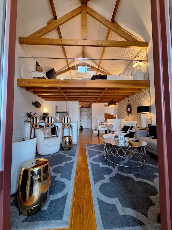 a living room with wooden ceilings and a large room with tables at Oporto Golden Apartment in Porto