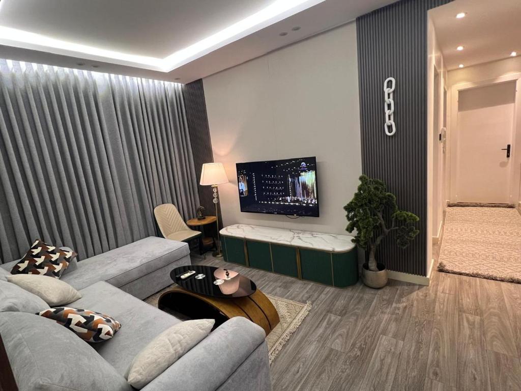 un soggiorno con divano e TV a schermo piatto di شقــة فخمـــة a Shaqra