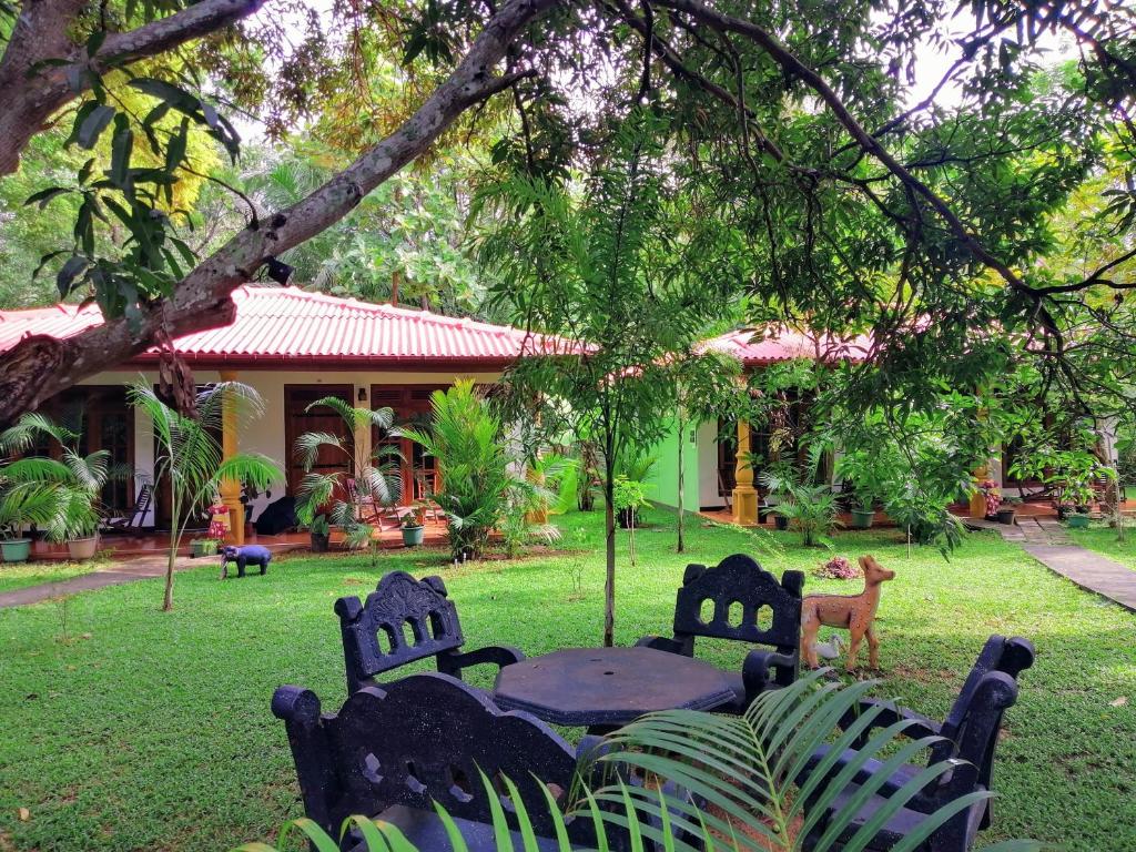 Una mesa y sillas frente a una casa en Sigiriya Ranasinghe Nature Villa &amp; Cabana, en Sigiriya
