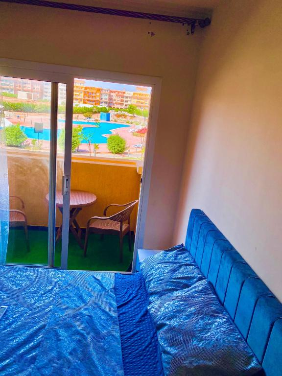 a room with a bed and a table and a window at Porto Sharm Family Chalet with Pool View in Sharm El Sheikh