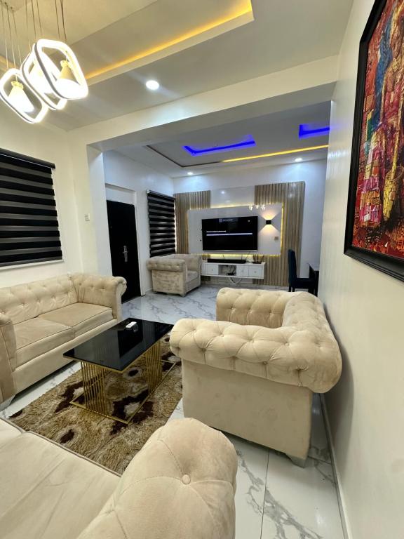 a living room with two couches and a tv at 2bedroom duplex in OguduGRA by Magnanimous shortlets 15 mins to the airport in Lagos